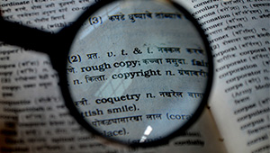 A small magnifying glass focusing on a thesaurus entry for copyright