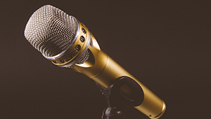 A golden microphone in a black stand