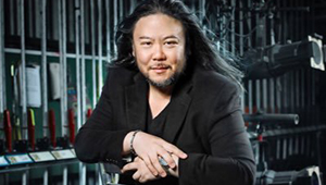 Stafford Arima, wearing a black suit-jacket and V-neck, backstage at a theatre